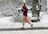 A man jogging outdoors, headphones on, focused on his daily podcast episode.