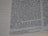 A close-up view of a page from a printed book, featuring text in two columns. The text is in a serif font and is centered, with a margin on the left side containing a series of dotted lines. The focus is on a section of the page, with the text appearing slightly blurred in places.