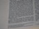 A close-up view of a page from a printed book, featuring text in two columns. The text is in a serif font and is centered, with a margin on the left side containing a series of dotted lines. The focus is on a section of the page, with the text appearing slightly blurred in places.