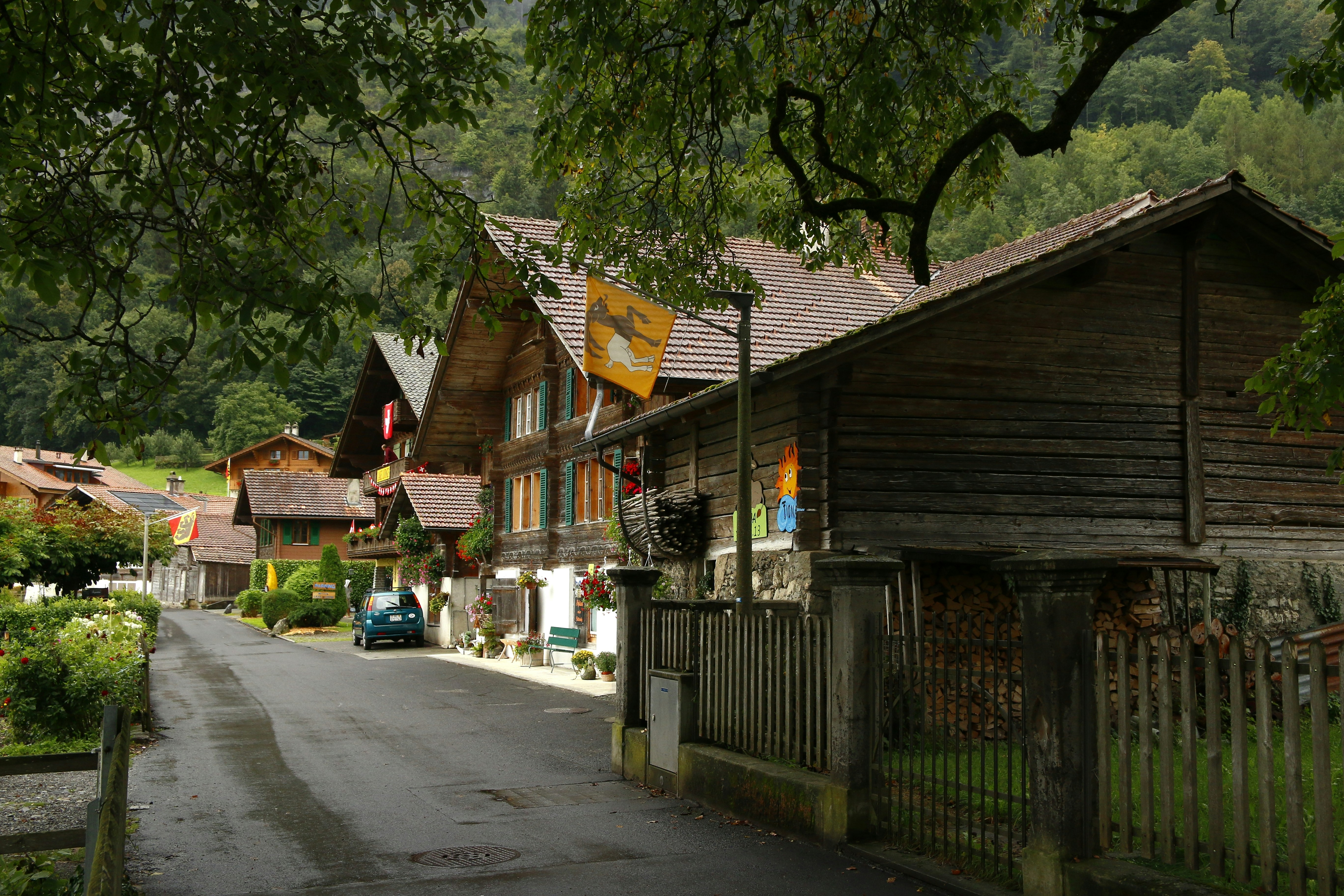 cars parked beside brown wooden house during daytime