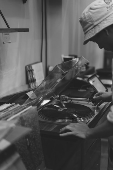 grayscale photo of person holding vinyl record