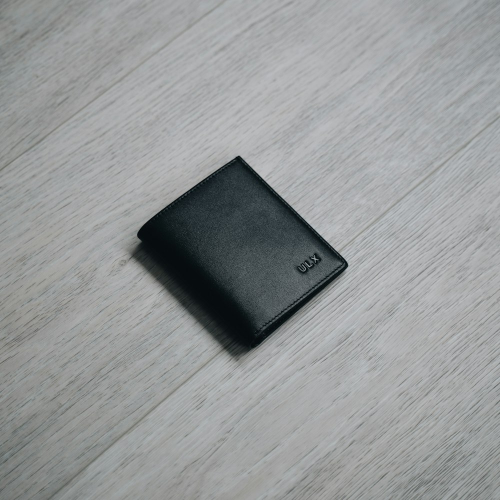 갈색 나무 테이블에 블랙 가죽 반접이식 지갑