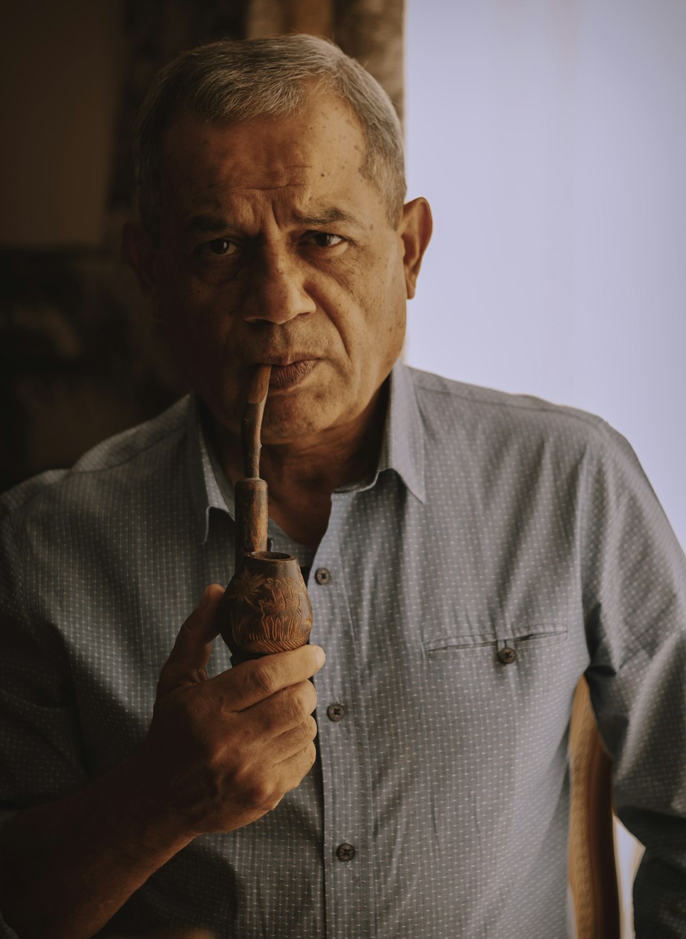 man in gray dress shirt smoking