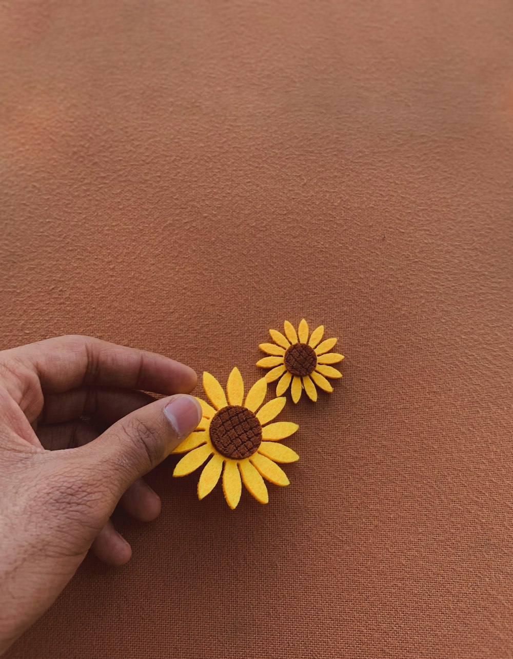 pessoa que segura o brinquedo plástico da flor amarela