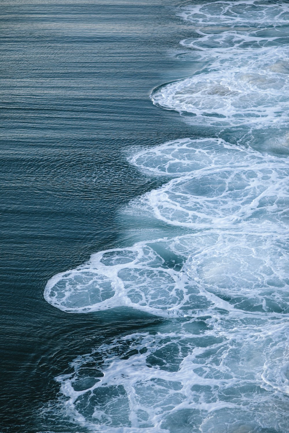 ocean waves crashing on shore during daytime