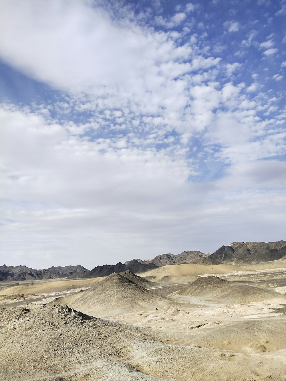 brown mountain under blue sky and white clouds during daytime