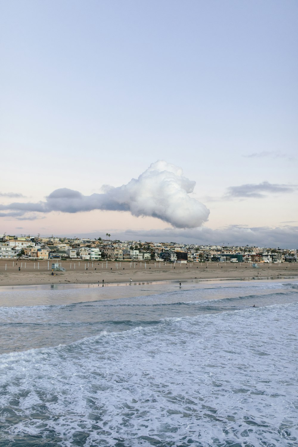 nuvens brancas sobre os edifícios da cidade e o mar durante o dia