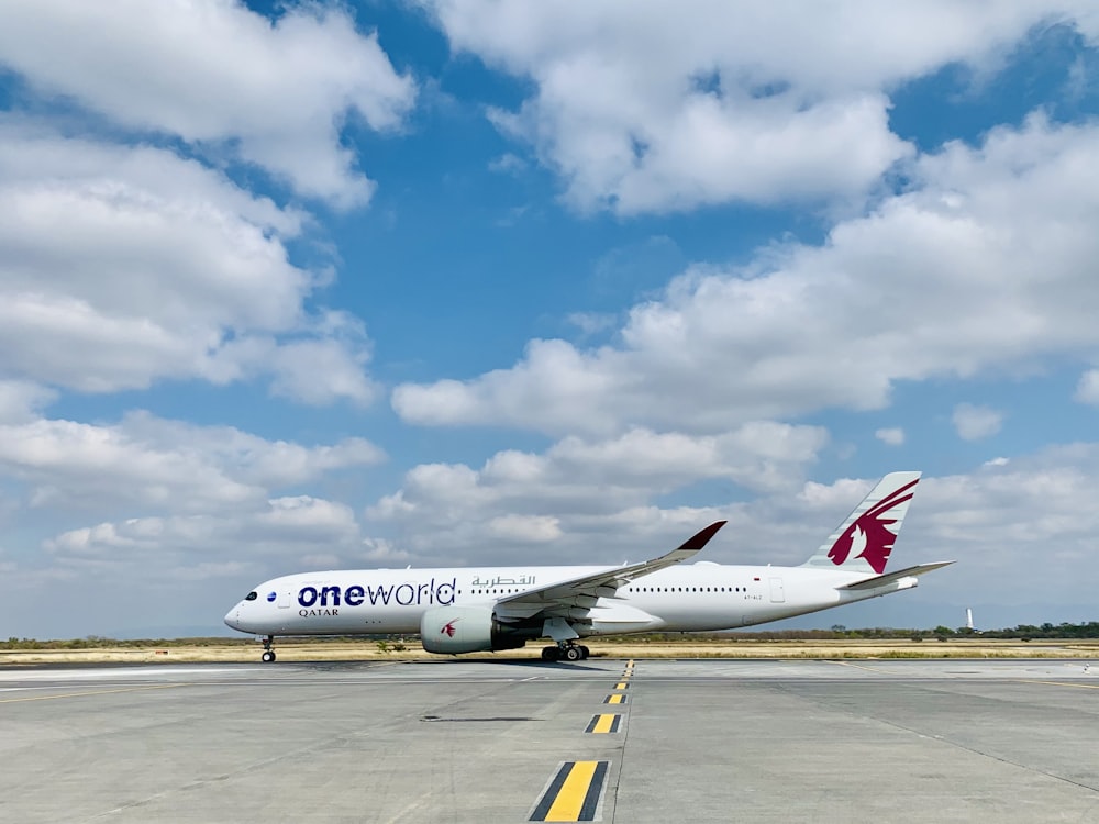 Avion de ligne blanc et rouge sur l’aéroport pendant la journée