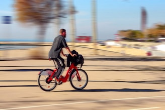man in black jacket riding red motorcycle on road during daytime