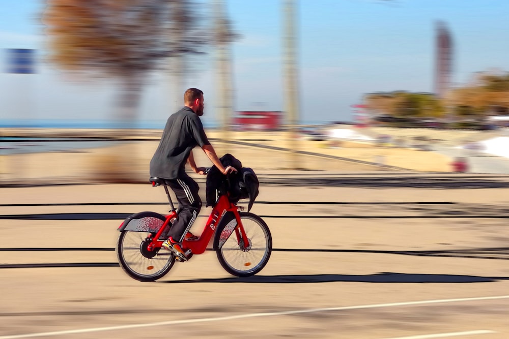 homem na jaqueta preta que monta a motocicleta vermelha na estrada durante o dia