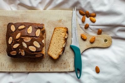 Smooth almond butter spread on a slice of rustic bread with whole almonds nearby