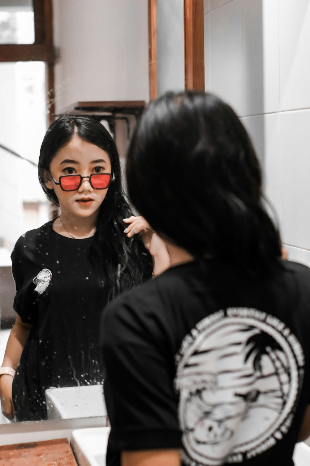 Femme en T-shirt à col rond noir portant des lunettes à monture noire