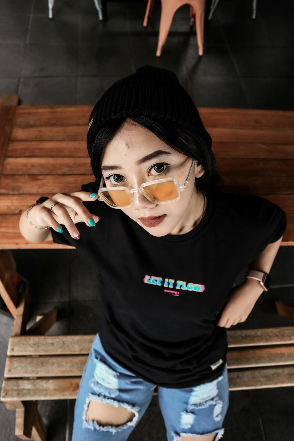 woman in black crew neck t-shirt wearing black knit cap and black framed eyeglasses