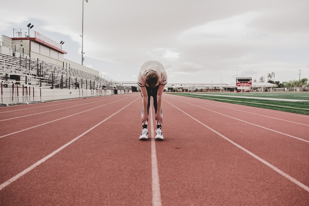 man in black shorts running on track field during daytime