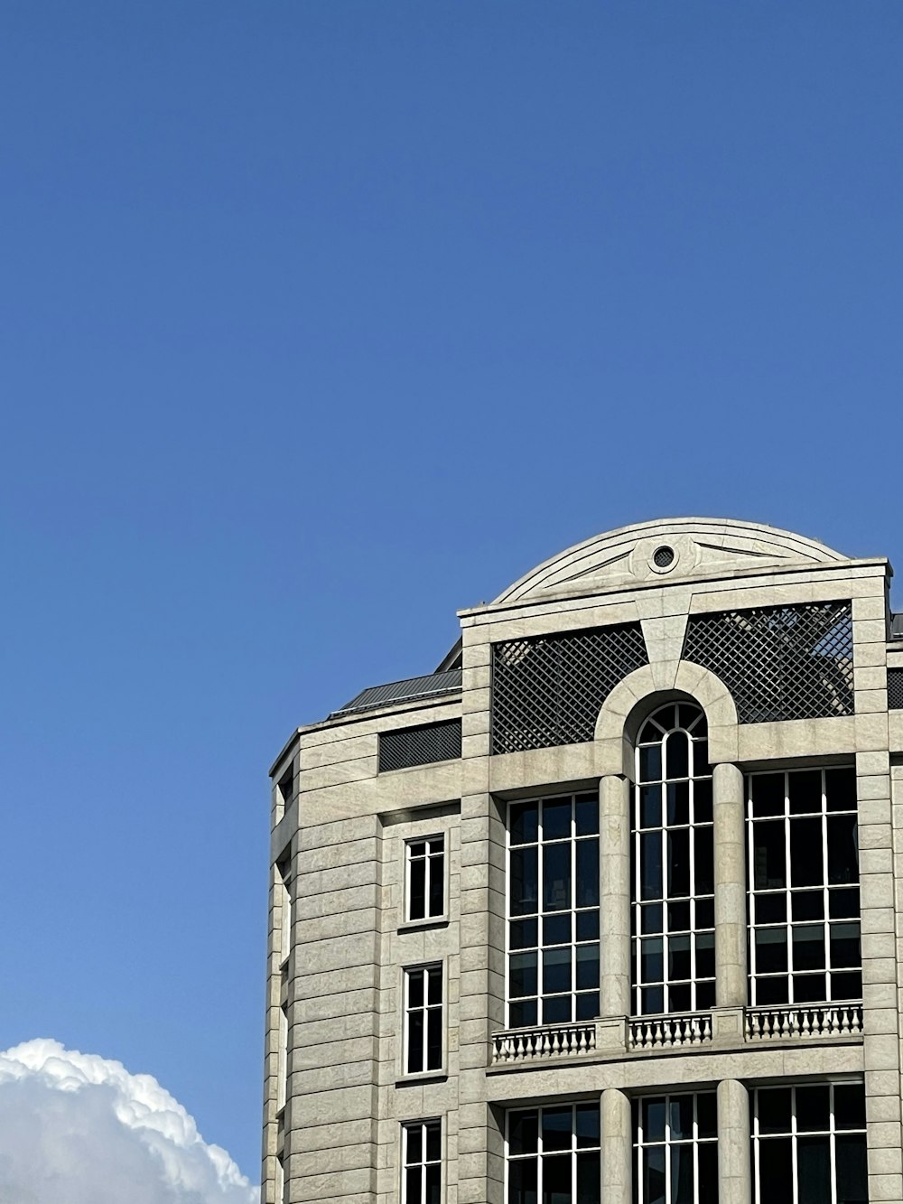 Weißes Betongebäude unter blauem Himmel tagsüber