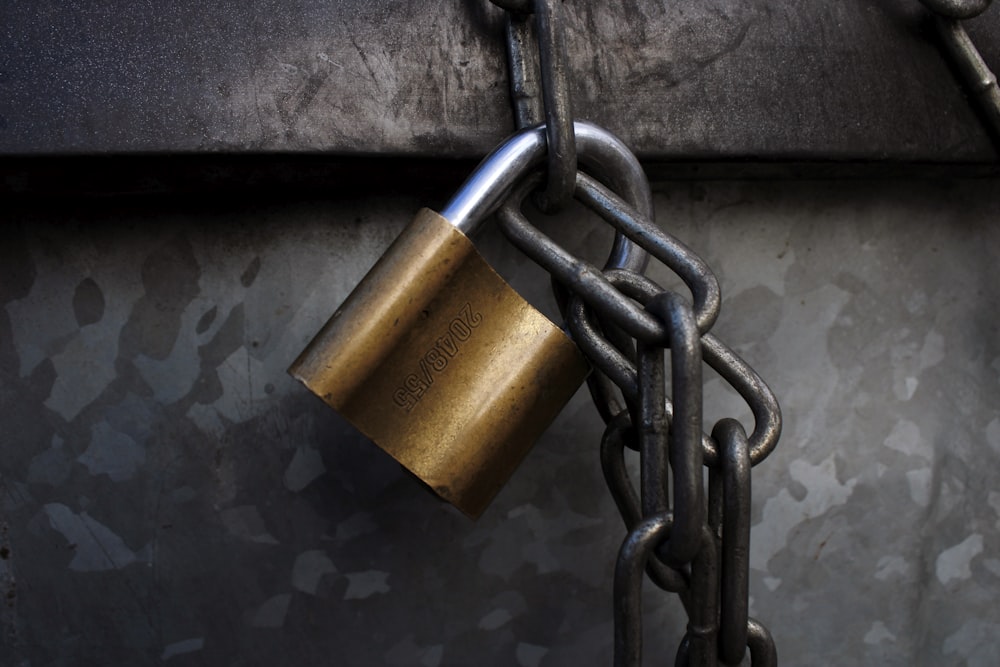 brass padlock on grey metal chain