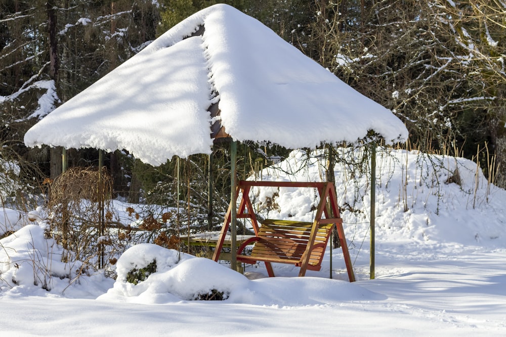 braune Holzschaukel mit Schnee bedeckt