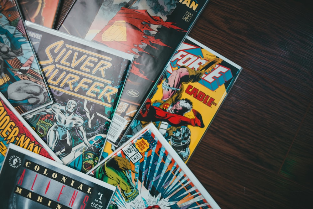 a pile of comics sitting on top of a wooden table