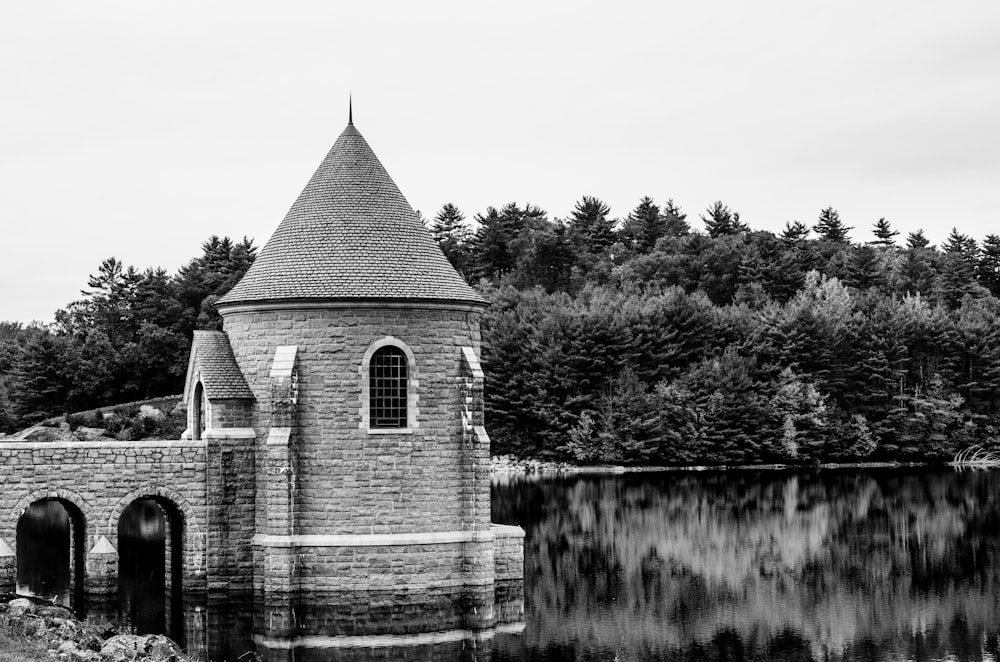 grayscale photo of church near river