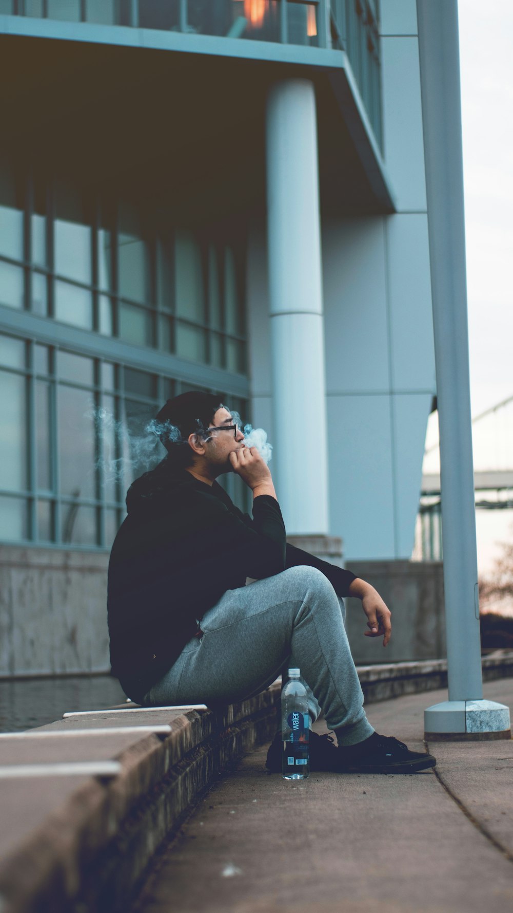 woman in black long sleeve shirt and blue denim jeans sitting on brown wooden bench during