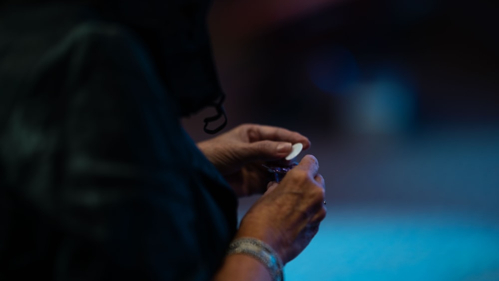 person in silver ring holding white smartphone