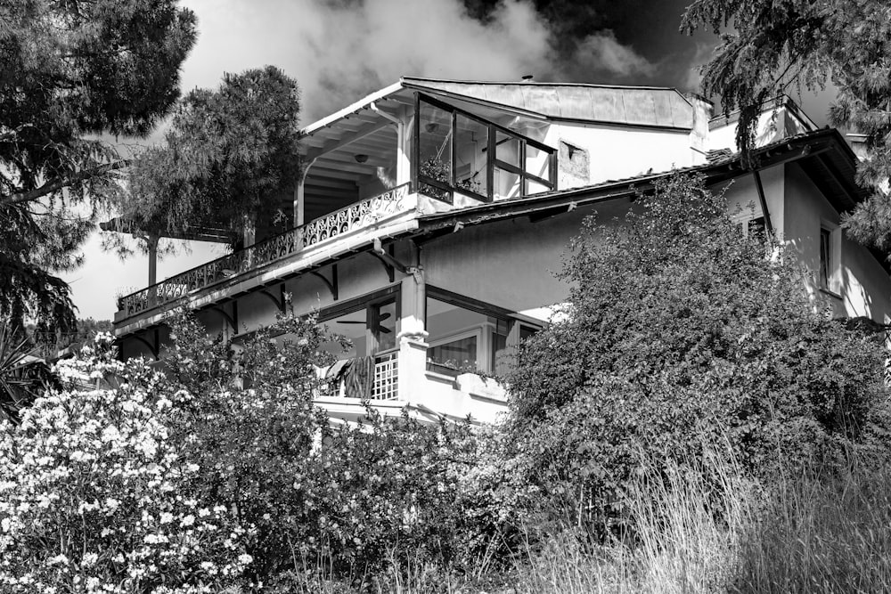 grayscale photo of a house near trees