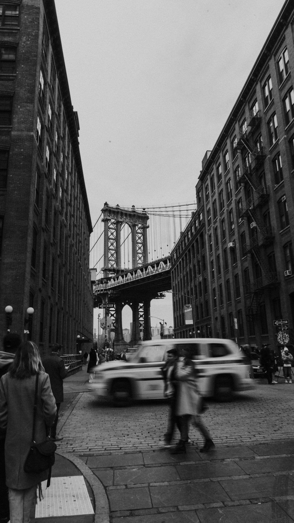 grayscale photo of cars on road near building