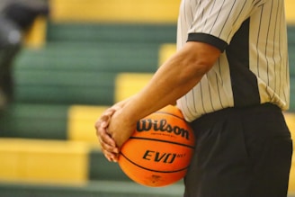 man in white shirt holding basketball