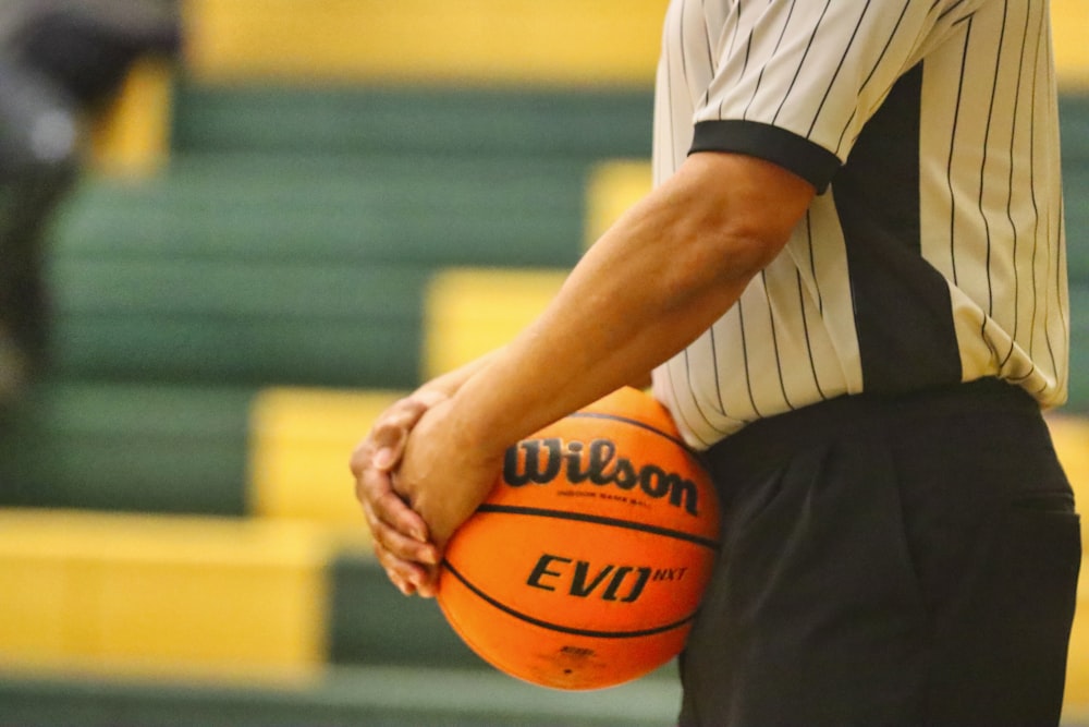 man in white shirt holding basketball