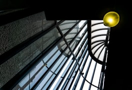 Covered outdoor area with thermoacoustic glass roofing glowing under soft light.