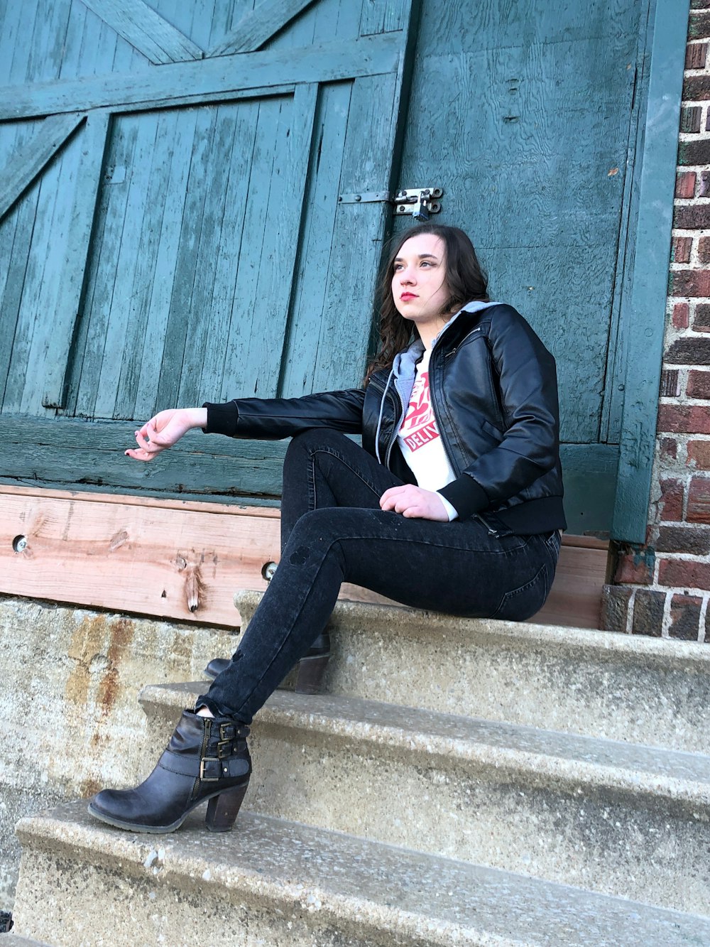 man in black blazer sitting on brown wooden bench