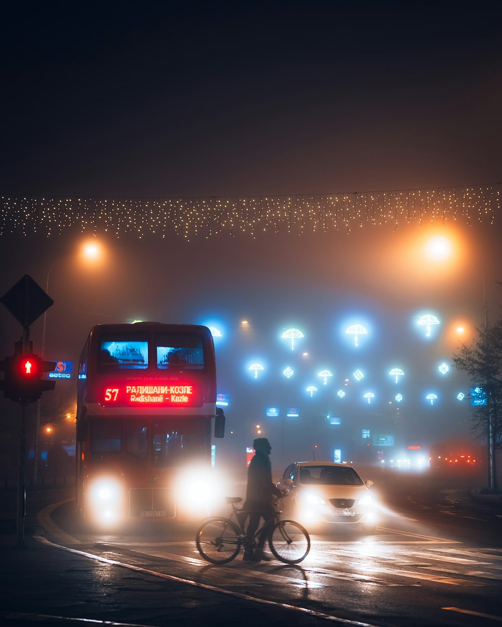 homme en veste noire faisant du vélo sur la route pendant la nuit