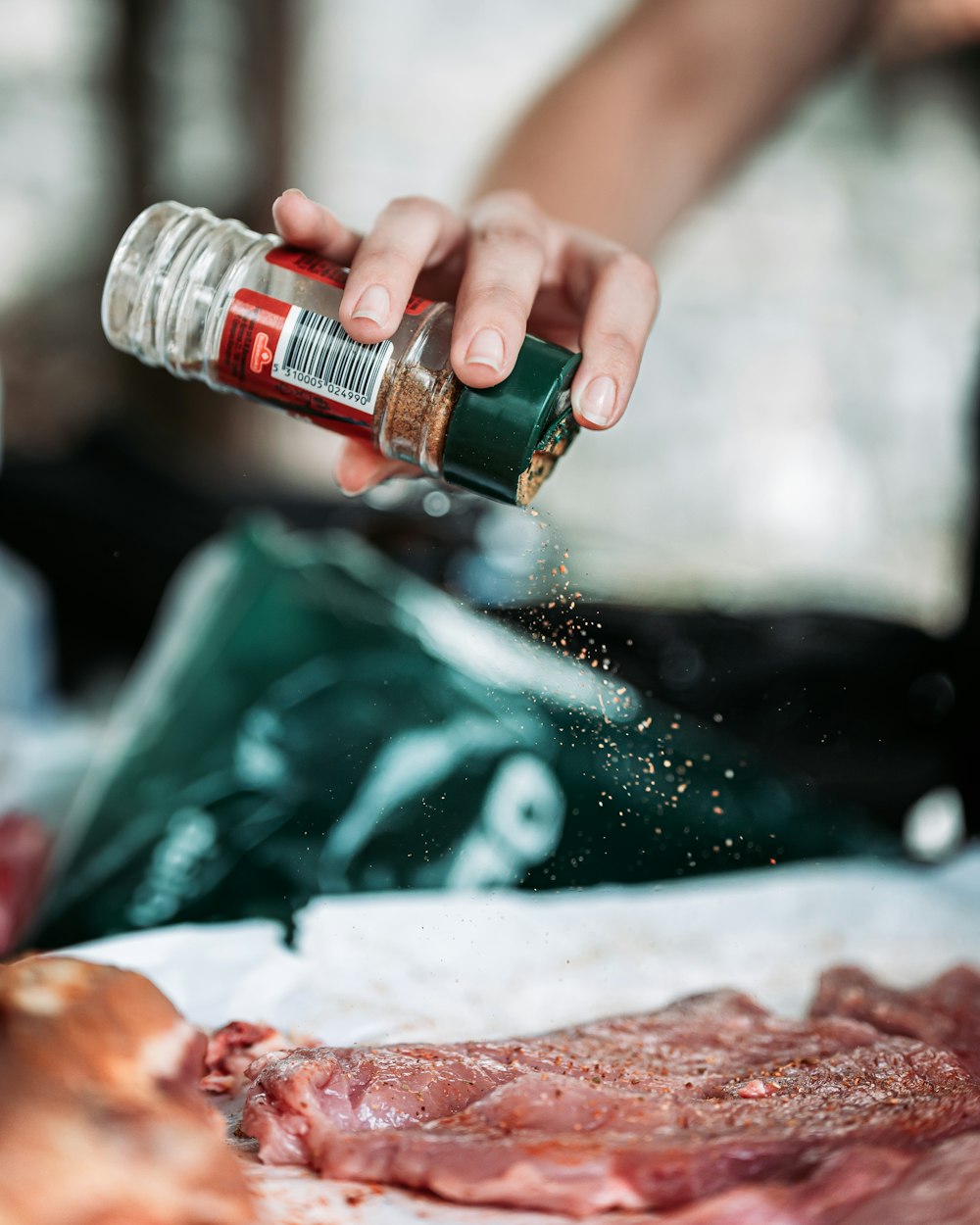 person holding green and red bottle