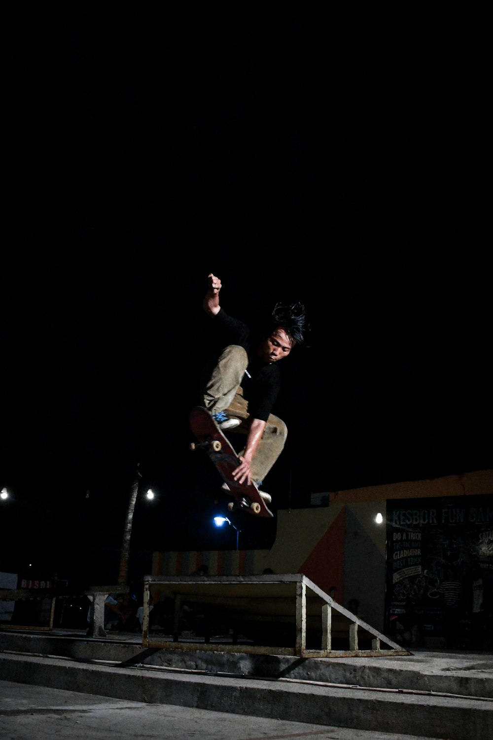 man in black t-shirt and black pants playing skateboard during nighttime