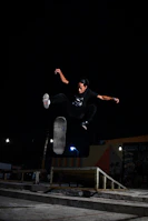 A skater soaring in a jump with the ice rink's glowing arena softly blurred in the background