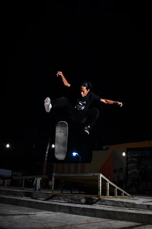 A skater soaring in a jump with the ice rink's glowing arena softly blurred in the background