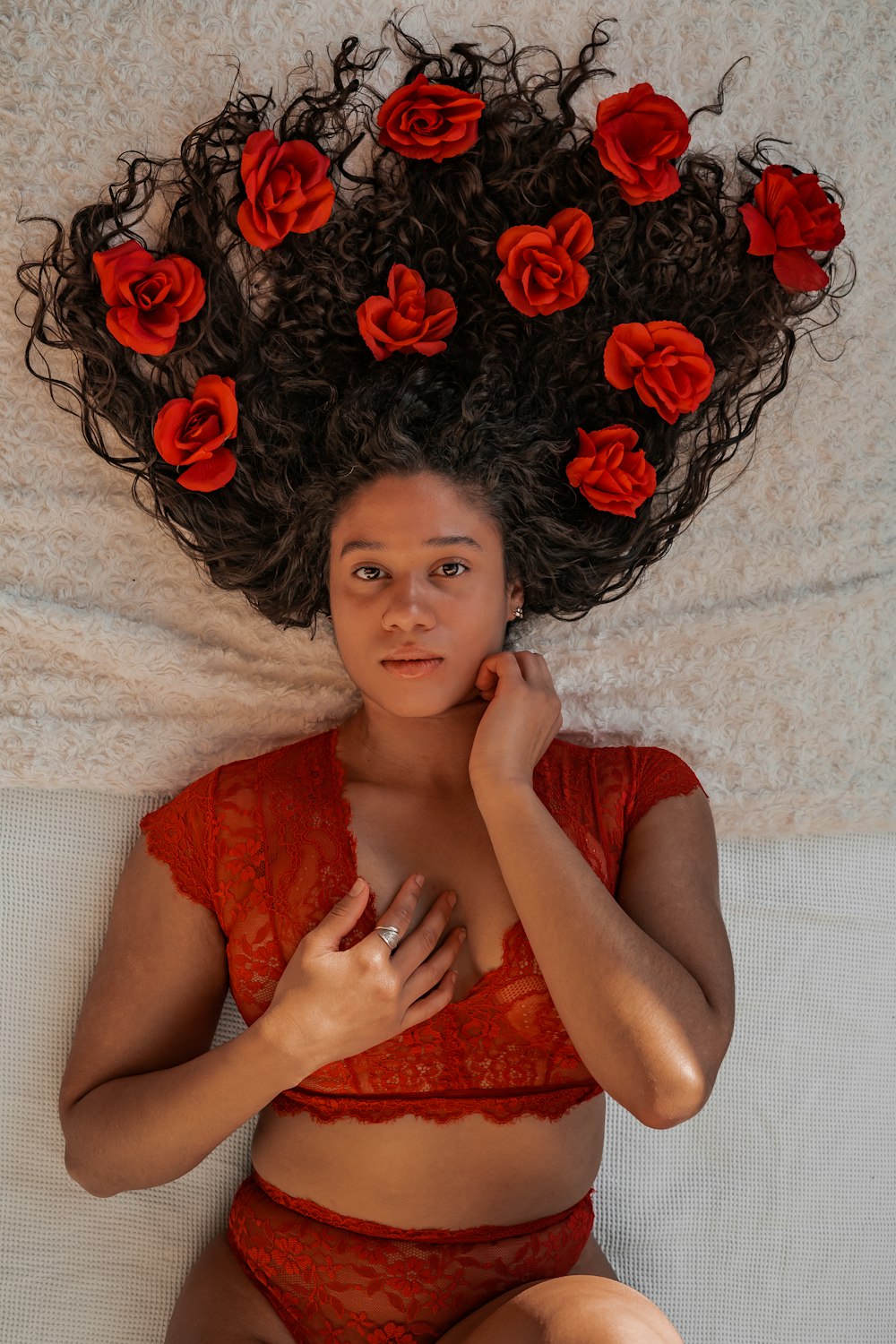 woman in red dress lying on white textile