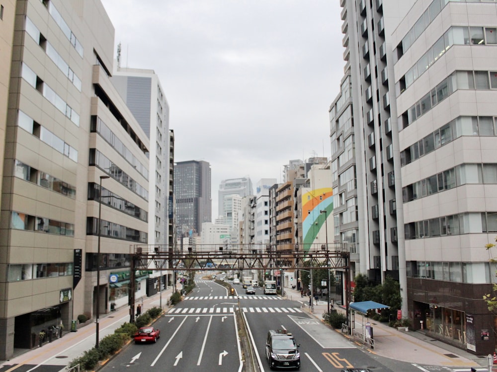 cars on road between high rise buildings during daytime