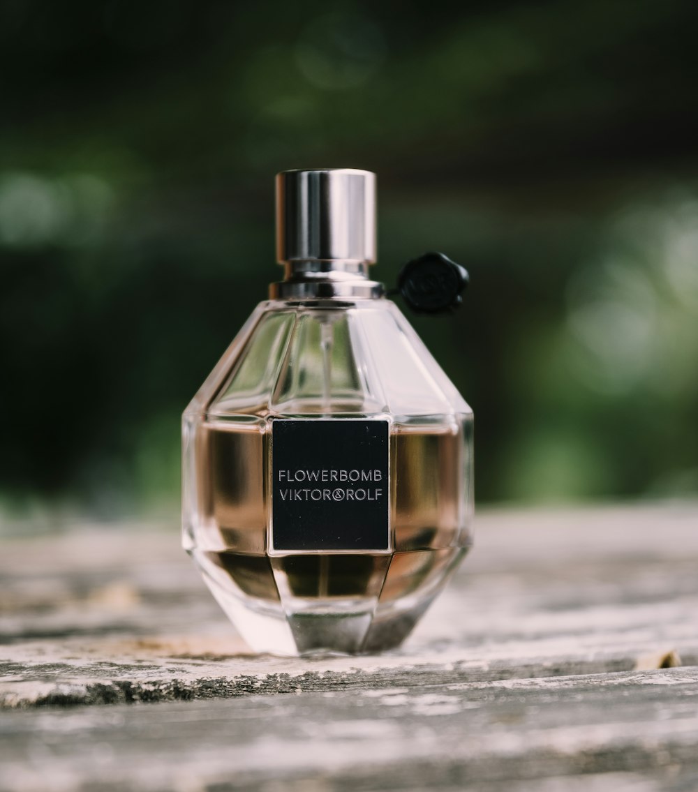 frasco de perfume de vidro transparente na mesa de madeira marrom