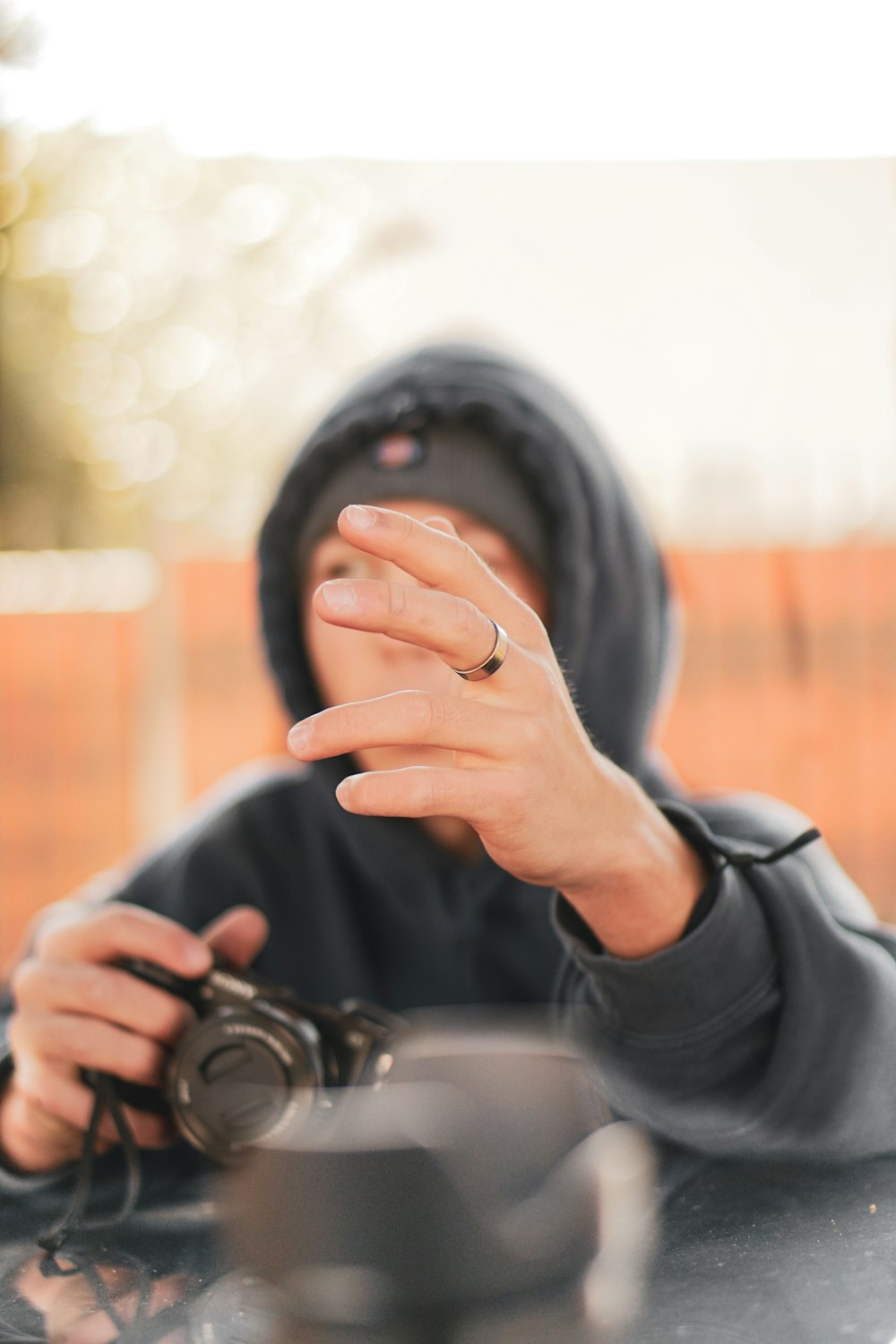 pessoa na jaqueta preta segurando a câmera dslr preta