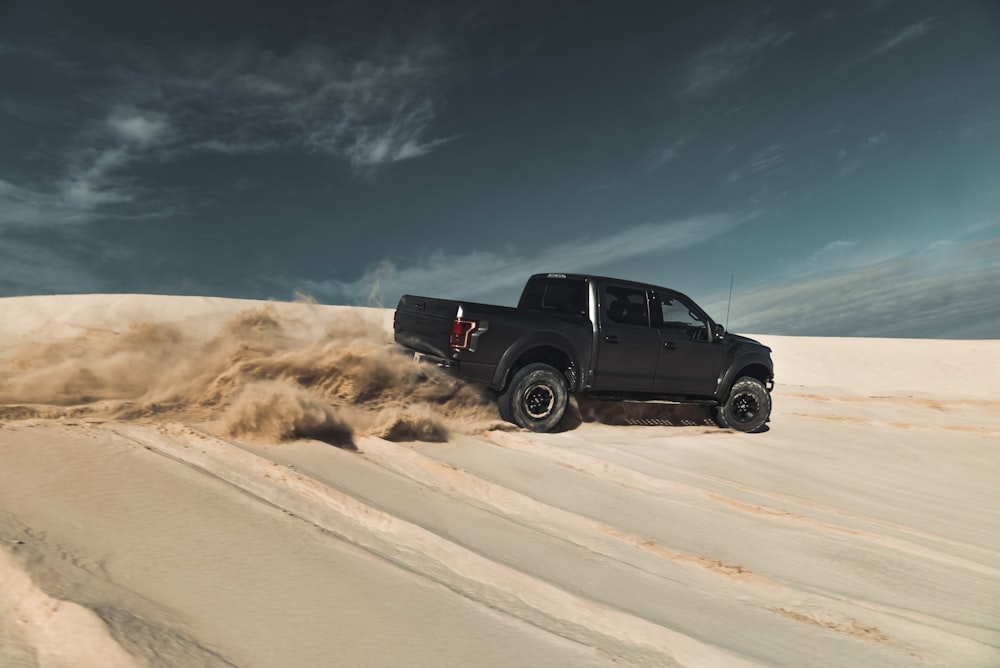 black crew cab pickup truck on desert under blue sky during daytime