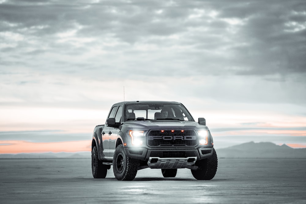 black chevrolet crew cab pickup truck on gray sand during daytime