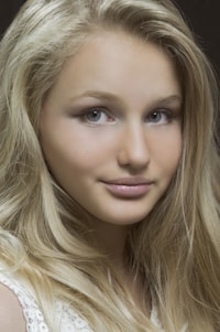 A close-up of a woman with beautifully platinum blonde hair, glowing under soft natural light.