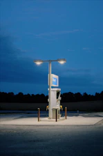 Close-up of a fuel nozzle dispensing diesel into a generator tank at sunset.