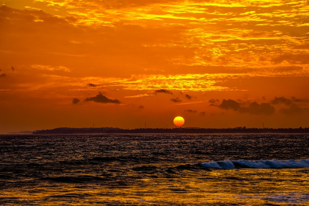 ocean waves crashing on shore during sunset