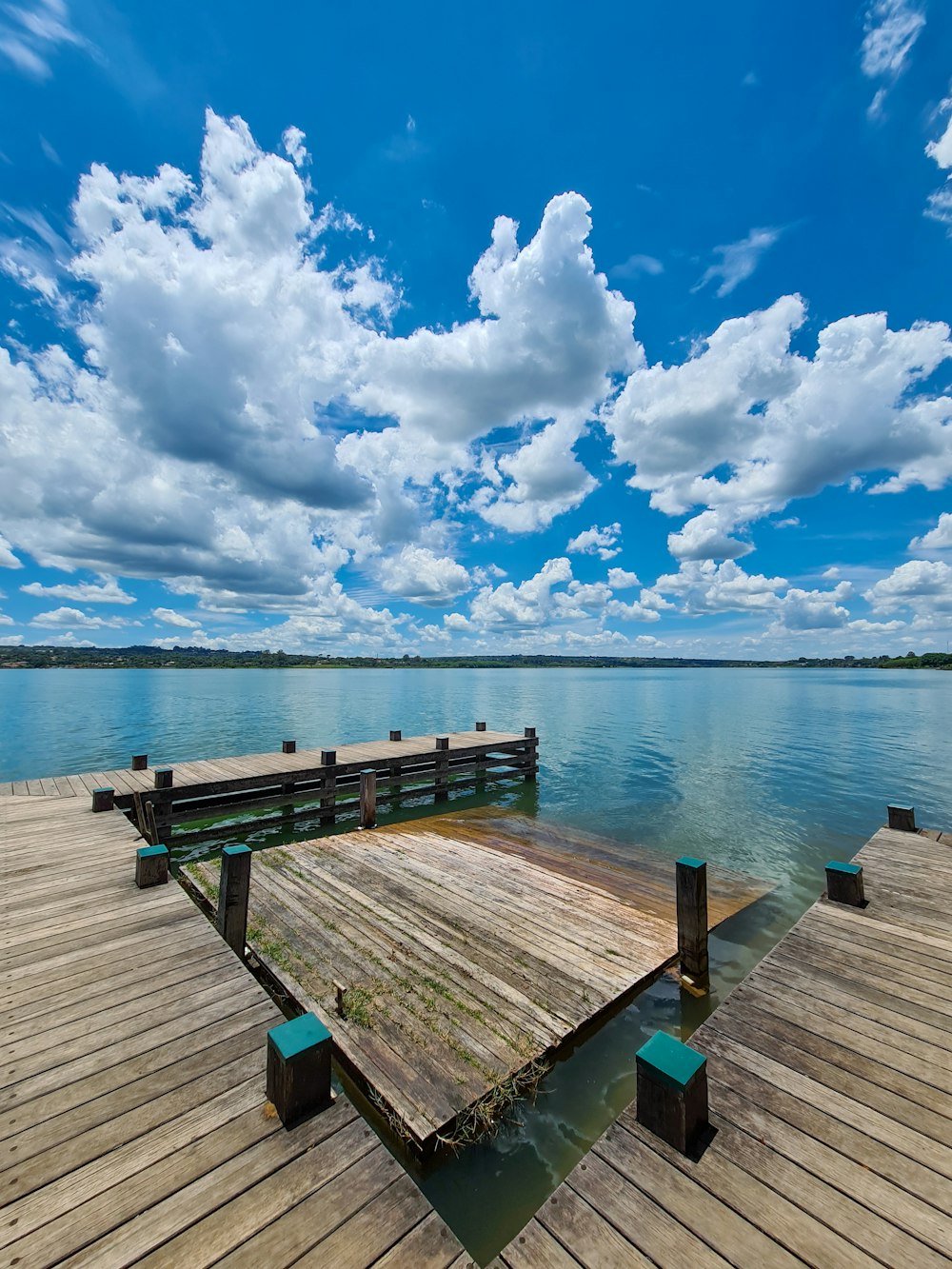 Braunes Holzdock auf See unter blau-weißem bewölktem Himmel tagsüber