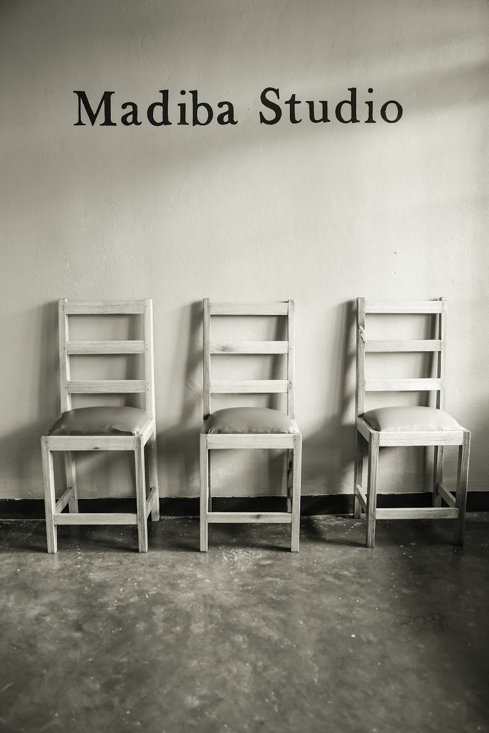 white wooden chair beside white wall