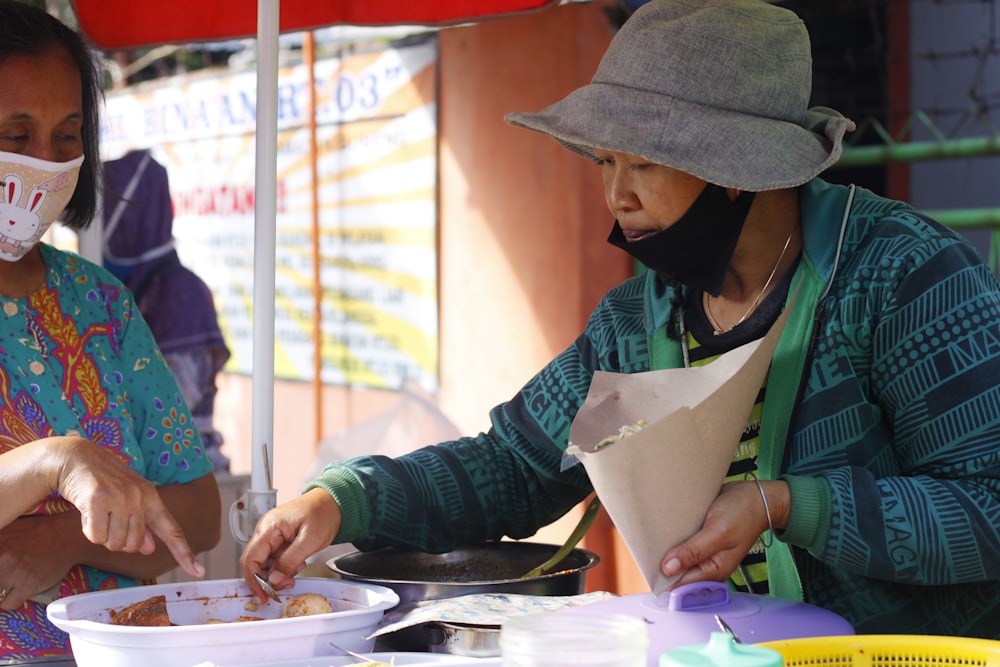 woman in green and white long sleeve shirt wearing green apron holding white paper