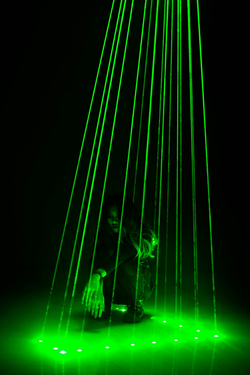 woman in black jacket and pants standing on green light