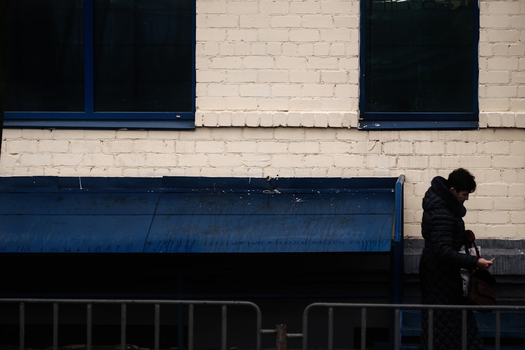 blue wooden bench beside white brick wall